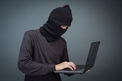 thieves-hold-credit-cards-using-laptop-computer-for-password-hacking-activities-min