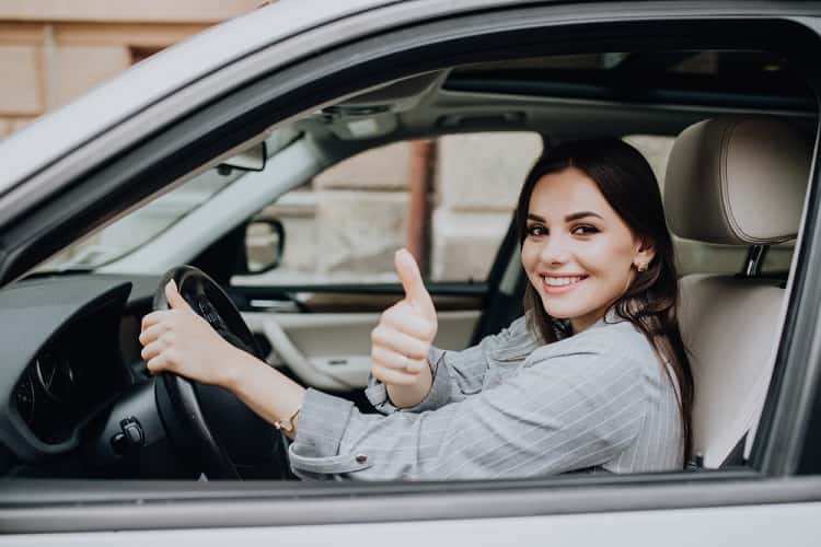 beautiful-young-latin-woman-driving-her-brand-new-car-and-showing-her-thumb-up-min