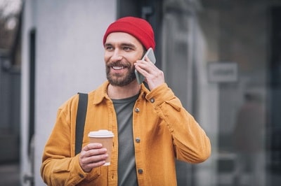 internet-hombre-chaqueta-naranja-telefono-min